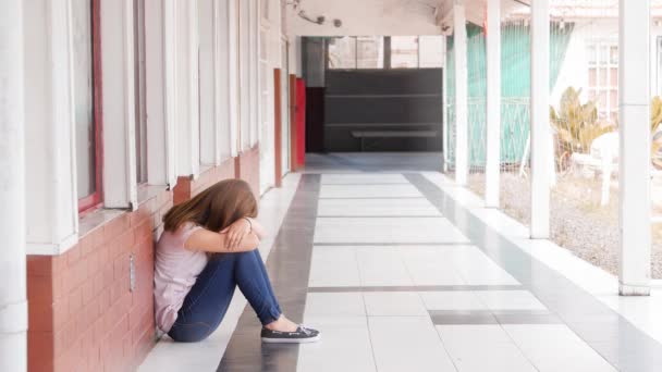beelden van gepest meisje zittend op de vloer van de hal op de middelbare school - Video