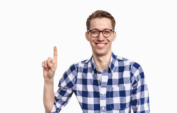 Cheerful guy in glasses pointing up - 写真・画像