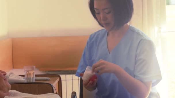 metraje de asiático enfermera ayudar mujer ir a la cama en retiro casa - Metraje, vídeo