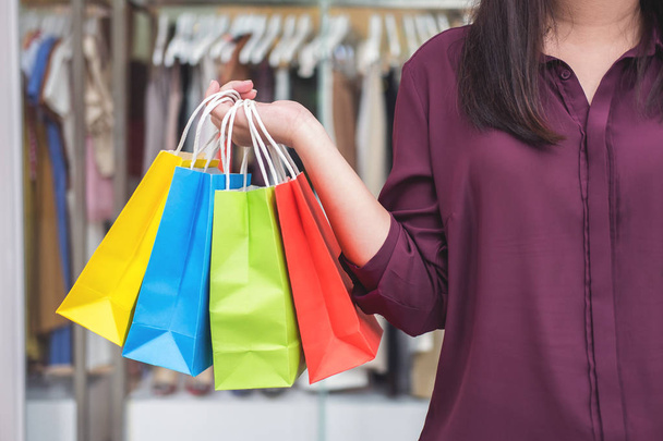 Consumerism, shopping lifestyle concept, Young woman standing and holding colorful shopping bags enjoying in shopping. - Foto, Bild