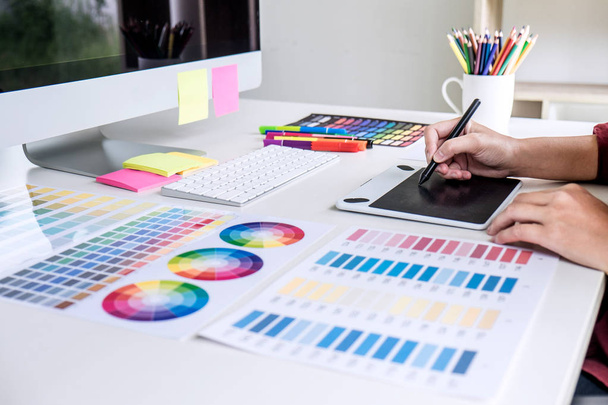 Obraz kobieta kreatywnych grafik pracy na wybór kolorów i rysowania na tablecie graficznym w miejscu pracy. - Zdjęcie, obraz
