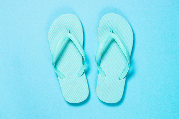 Blue flip flops on blue background. - Фото, изображение
