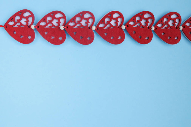Red hearts decoration on blue background. Valentines day background with hearts. Copyplace, space for text and logo.  - Foto, immagini