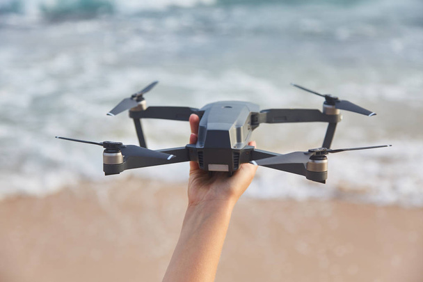 Drone in the female hand. Close-up. Girl launches drone. - Photo, Image