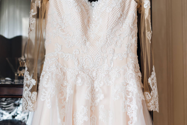 weiße Spitze auf einem Hochzeitskleid. Hochzeitskleid auf dem Kleiderschrank - Foto, Bild