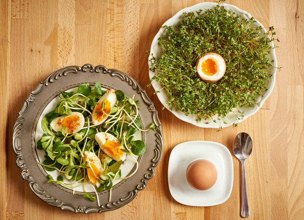 Vintage levy kevät aamiainen ituja ja karitsat salaattia ja keitettyjä munia ja krassi puinen pöytä
 - Valokuva, kuva