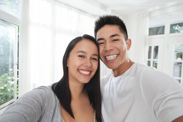 Χαρούμενο ζευγάρι λαμβάνοντας αυτοπορτρέτα στο νέο σπίτι τους - Φωτογραφία, εικόνα