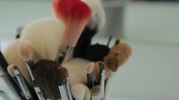 Set of brushes for make-up on table in dressing room. Fashion industry. Fashion show backstage - Кадры, видео