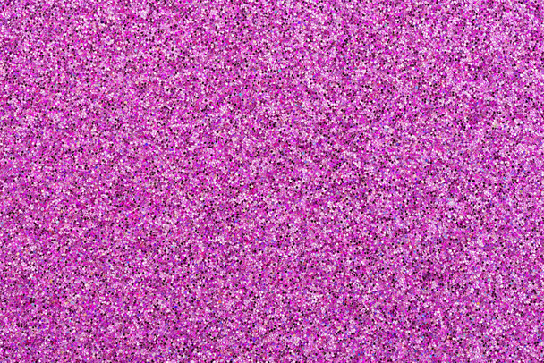 Primer plano sobre un fondo festivo de purpurina rosa. Hoja de confeti rosa y púrpura. Macro
. - Foto, Imagen