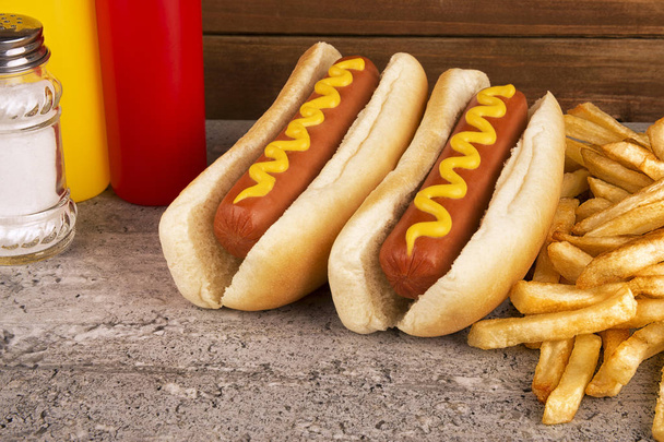 Duo of hot dogs and french fries on table. Fast food restaurant concept. Close up. - Photo, Image