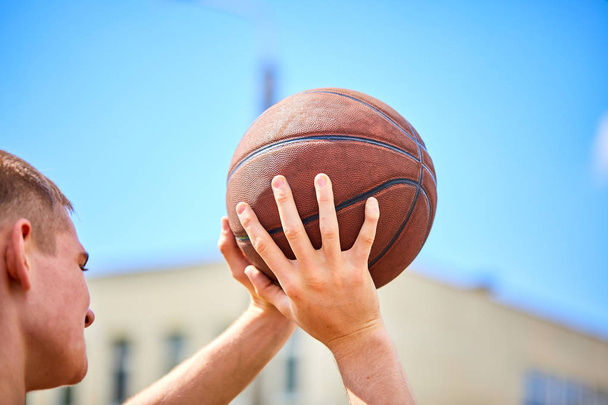 Mann hält Ball beim Basketball im Freien - Foto, Bild