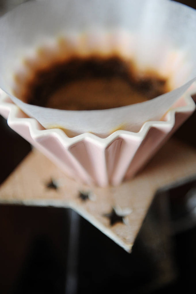 Fabricação de café manual alternativo em gotejador de cerâmica rosa com filtro de papel. Close-up
 - Foto, Imagem