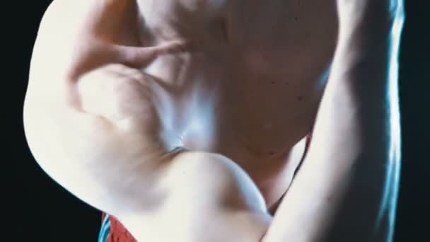 Seksikäs elin lihaksikas mies urheilija punaisissa shortseissa Flexing Arm lihakset mustalla taustalla
 - Materiaali, video