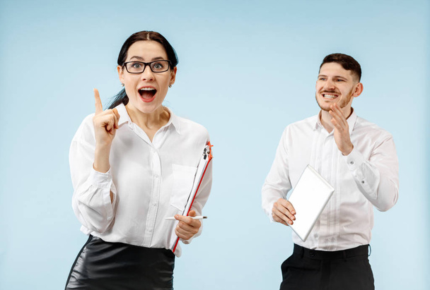 The surprised business man and woman smiling on a gray background - Фото, изображение