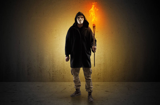 Man walking in an empty space with burning flambeau - Foto, afbeelding