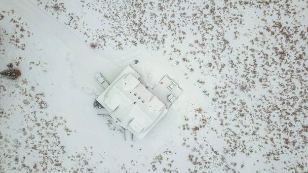 Vue aérienne de la maison de montagne couverte de neige en hiver
. - Photo, image