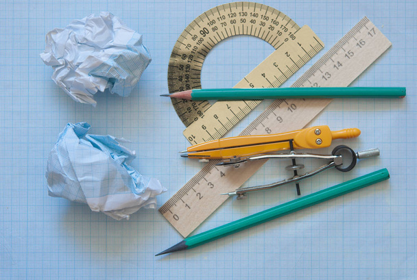 Mathematical instruments over the corner of a math graph paper with copy space for text. Math graphic tools concept - Photo, Image