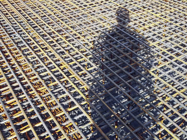 Der Schatten eines Bauarbeiters auf den Betonrosten. Schattenwurf des Rahmens diagonal - Foto, Bild