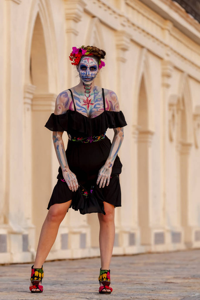 Nádherný hispánský bruneta model pózuje s tradiční lebka cukr make-up barva pro mexický festival. - Fotografie, Obrázek