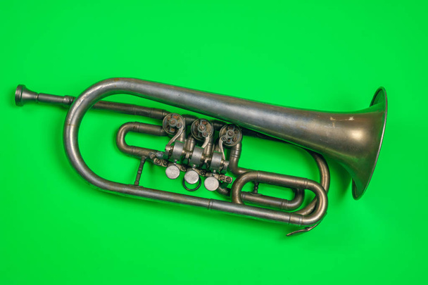 Trompeta de plata vieja sobre un fondo verde
 - Foto, imagen