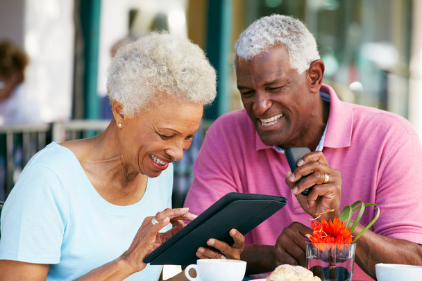 Senior Couple Using Tablet Computer At Outdoor Cafe - Photo, image