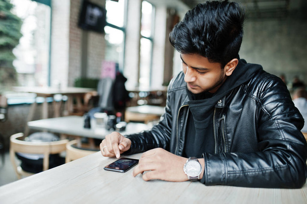 Asian male casual man holding smartphone, tapping on screen while sitting on cafe. - Foto, Bild