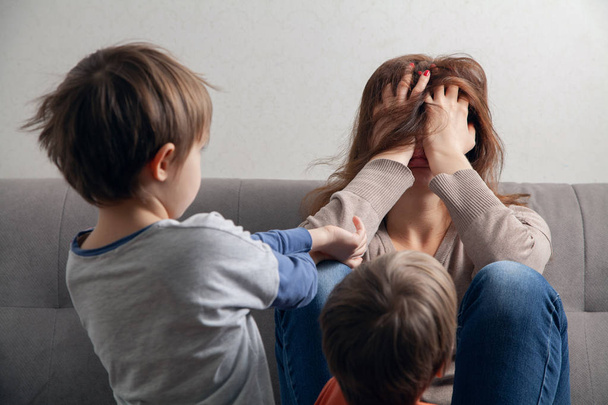Woman mom is tired in depression and children are boys. - Foto, Bild