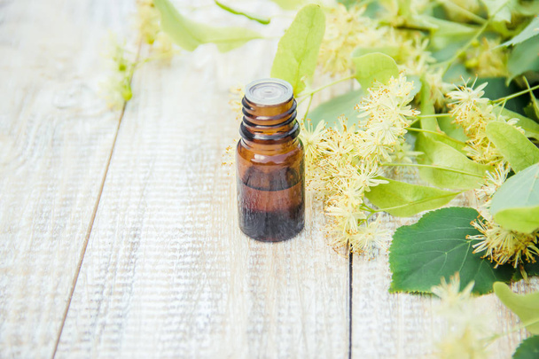linden extract and flowers in a small bottle. Selective focus. nature. - Photo, Image