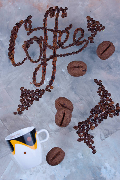 Delicious and fragrant coffee in the form of coffee, with grains of coffee, and the inscription on a light background. - Photo, Image