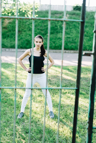Joven hermosa chica haciendo ejercicios por valla en el parque
 - Foto, Imagen