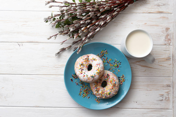 Donut on a blue plate on a wooden white background - Φωτογραφία, εικόνα