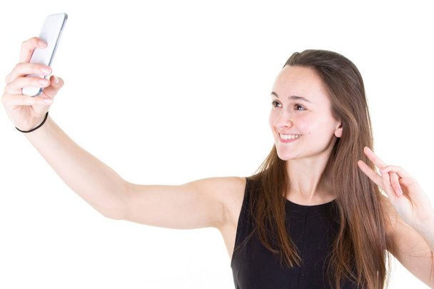 Портрет молодої привабливої жінки, що робить фото селфі з смартфоном на білому тлі
 - Фото, зображення