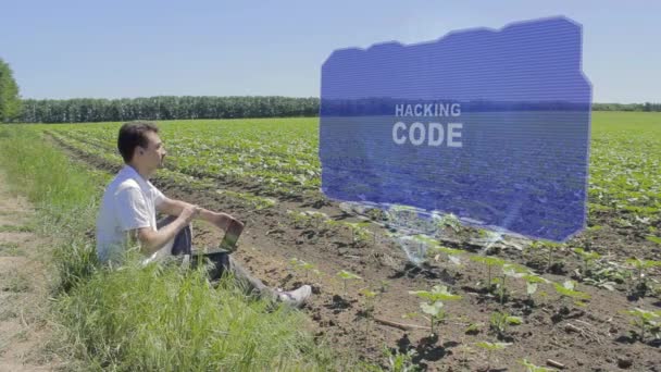 Man is working on HUD holographic display with text Hacking code on the edge of the field - Footage, Video