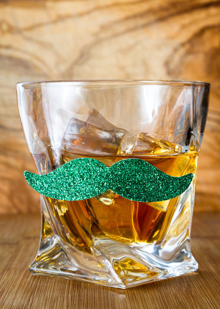 Lähikuva lasi viskiä vihreät viikset yli puinen tausta käsitteenä Saint Patricks päivä
 - Valokuva, kuva