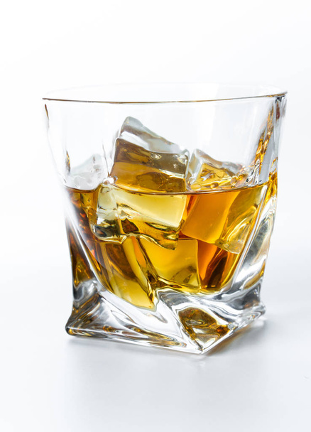 Close up of a tumbler glass with straight Kentucky bourbon served on the rocks isolated on a white background - Fotoğraf, Görsel