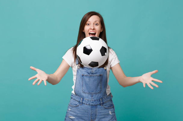 Surprised funny young woman football fan cheer up support favorite team throwing soccer ball isolated on blue turquoise background. People emotions, sport family leisure concept. Mock up copy space - Photo, Image
