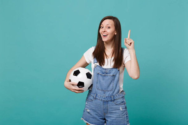 Ενθουσιασμένος γυναίκα φίλαθλος φτιάξει υποστήριξη αγαπημένη ομάδα με μπάλα ποδοσφαίρου κρατήστε πατημένο το δείκτη με μεγάλη νέα ιδέα απομονώνονται σε μπλε φόντο τιρκουάζ. Άνθρωποι συναισθήματα αθλητισμό αναψυχής από την οικογένεια έννοια - Φωτογραφία, εικόνα