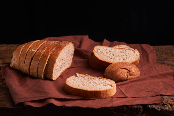 čerstvě upečený chléb na tmavý dřevěný kuchyňský stůl. Selektivní fokus - Fotografie, Obrázek