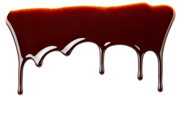 закрытие шоколадного сиропа, протекающего на белом фоне - Фото, изображение