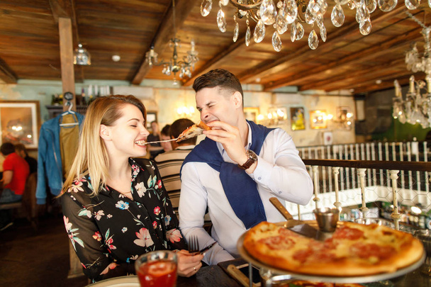 young beautiful couple eating pizza in a restaurant - Foto, Imagem