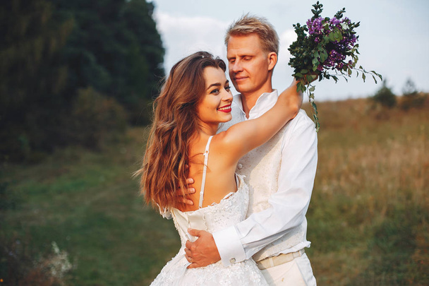 Beautiful wedding couple in a summer field - Fotografie, Obrázek