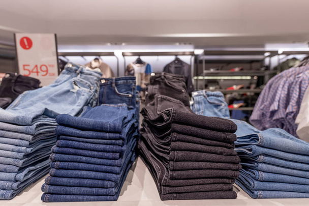 Stack of jeans in the store. Shopping mall. Shopping concept. - Photo, Image