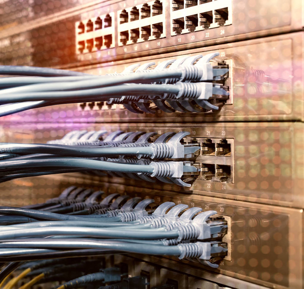 Interruttore di rete e cavi ethernet nella sala server. Corde di patch collegate al router nel data center. Contesto della tecnologia orizzontale
 - Foto, immagini