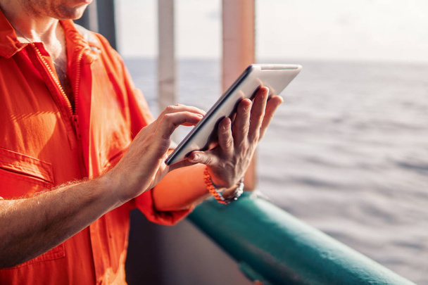 chief officer or captain on deck of vessel or ship watching digital tablet - Photo, image