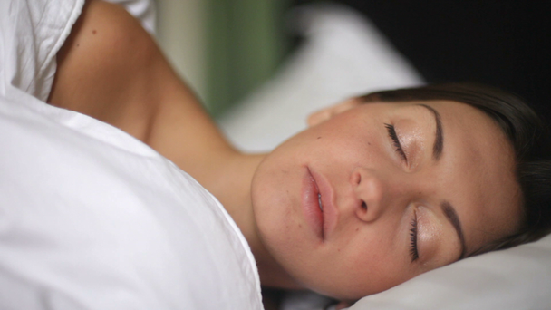 Portret van een jong meisje dat op een kussen slaapt - Video