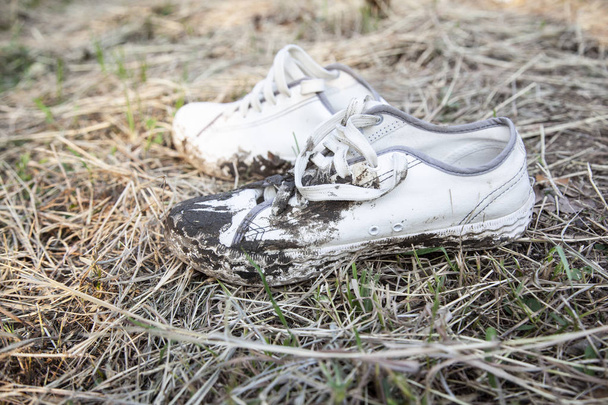 Detailní záběr záběr špinavé boty na suché trávy - Fotografie, Obrázek