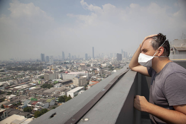 ενήλικα άνδρα που φοράει προστατευτική μάσκα στη στέγη με αστικό τοπίο - Φωτογραφία, εικόνα