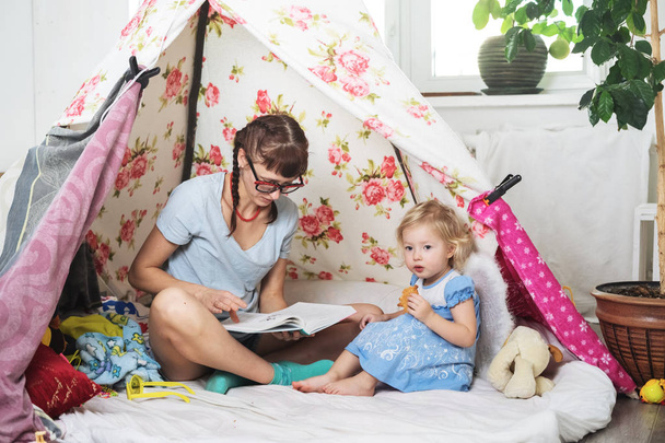 Family time: Mom and some of the sisters children play at home in a childrens homemade tent. - Foto, afbeelding