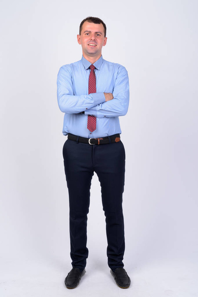 Full body shot of happy businessman smiling with arms crossed - Photo, image