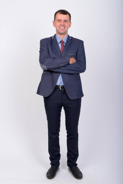 Full body shot of happy businessman in suit smiling with arms crossed - Фото, зображення